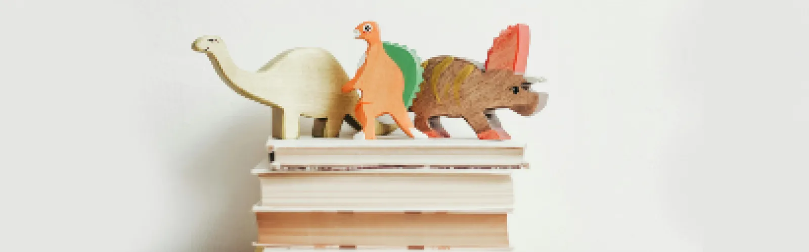 A stack of books with dinosaurs